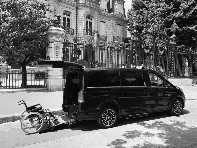 Accessible Mercedes van with wheelchair ramp parked in front of a Haussmann-style building in Paris, ideal for PMR airport transfers to CDG and Orly.